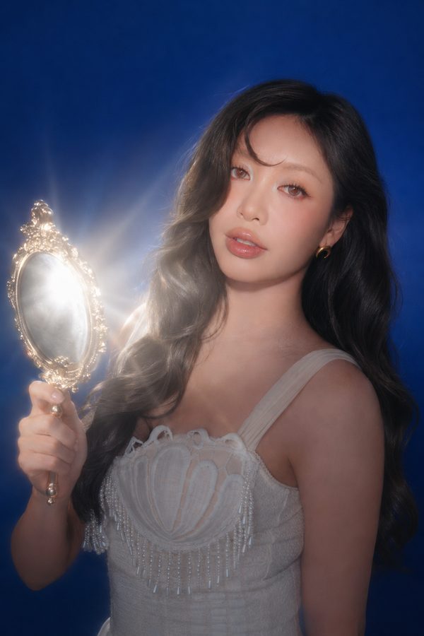Michelle Phan holding a hand mirror